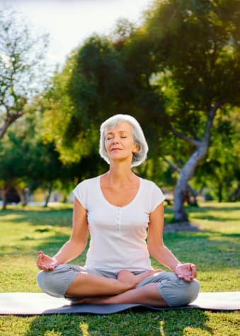 Mature woman doing yoga in the park.